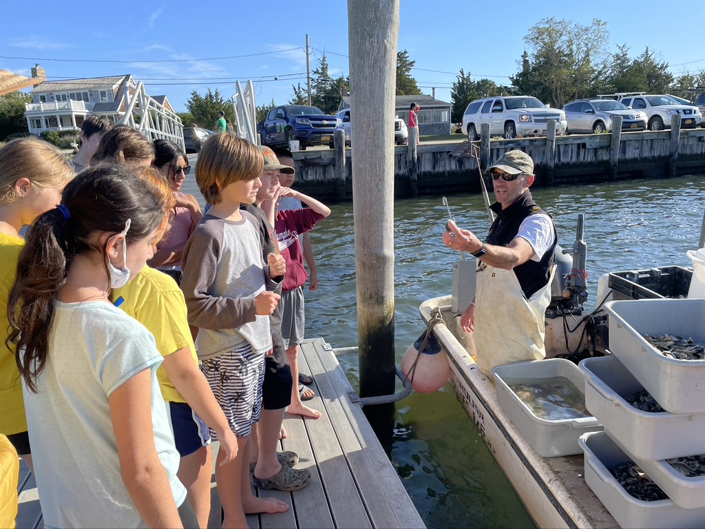 Director of the East Hampton Shellfish Hatchery and students from the East Hampton Middle School who are members of the Surfrider Club learning about oysters and how important they are to our waterways.  