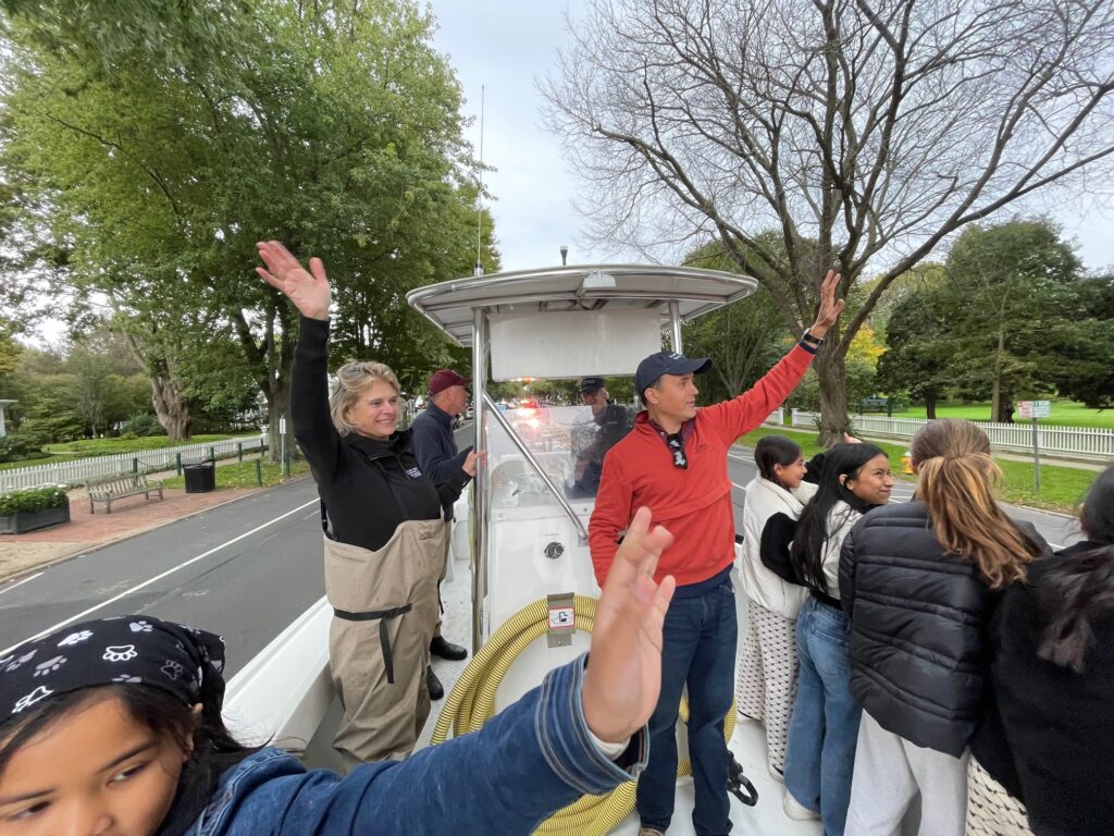 Southampton Town Trustee Ann Welker and East Hampton Town Trustee David Cataletto, with his students, are waving to the people at the Town of East Hampton's 375th Anniversary Parade.