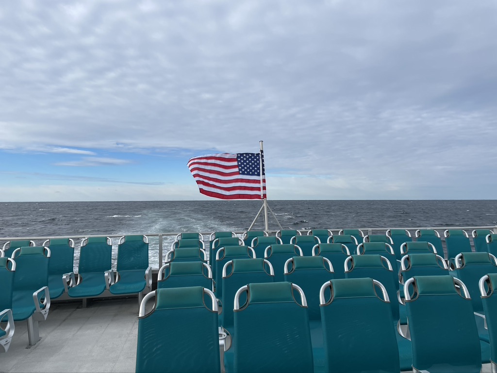 Stern of the boat with the wind blowing the American flag.
