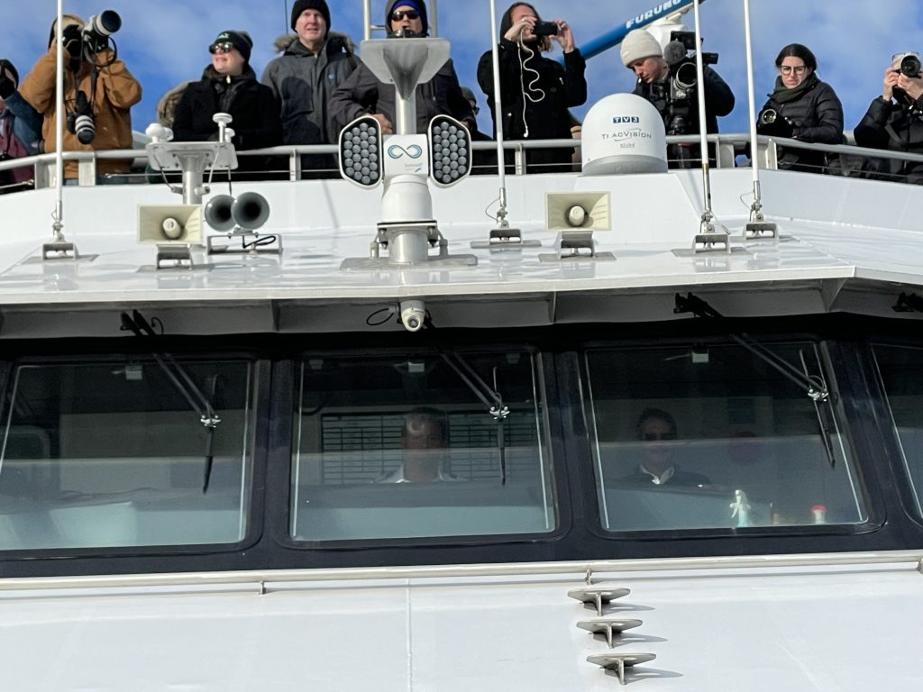 Top of the boat, viewers see the wind turbine construction ahead.