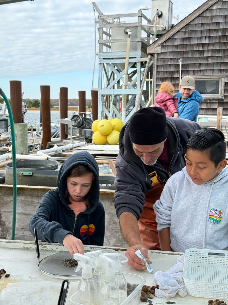 Rob Vasiluth of SAVE Environmental and students from EH Middle School eelgrass gluing