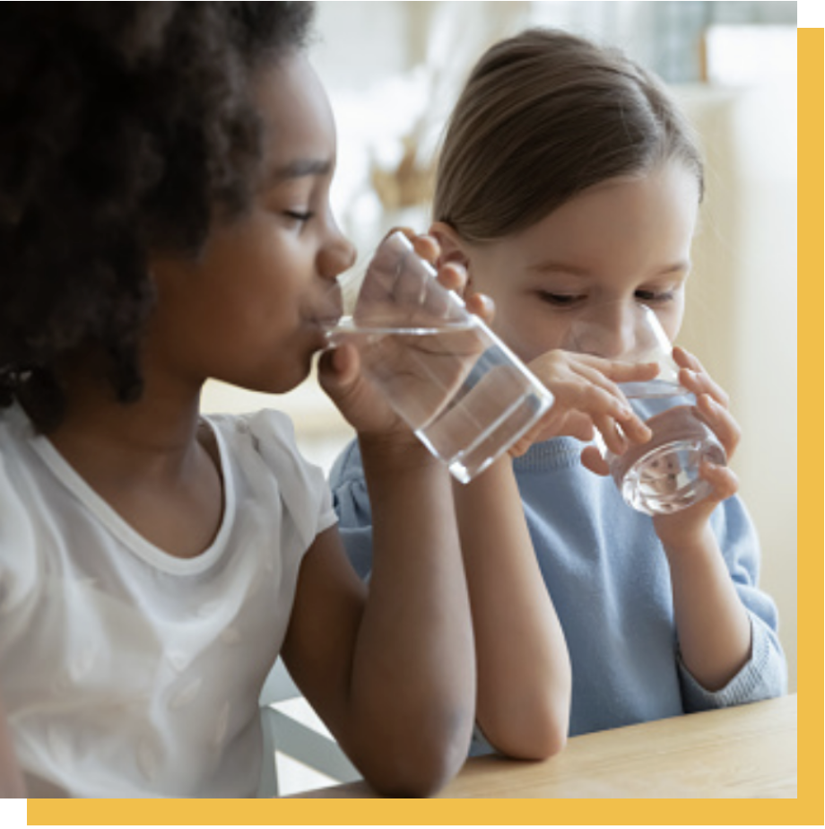Children drinking water from glasses 